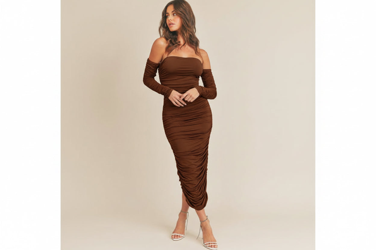 A blue Bella Ruche dress with detachable sleeves, ruching throughout, and a back slit. The dress features a tube silhouette and a zipper closure at the back.